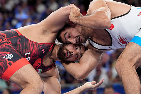 Amir Hossein Zare, in red, and Taha Akgul compete men's freestyle 125kg semifinal wrestling